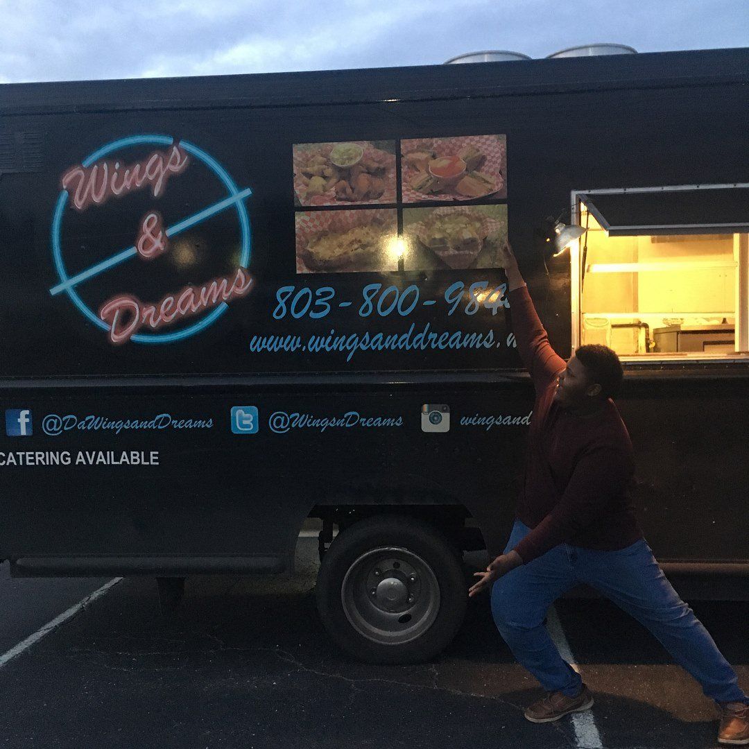 A person points to a food truck labeled 