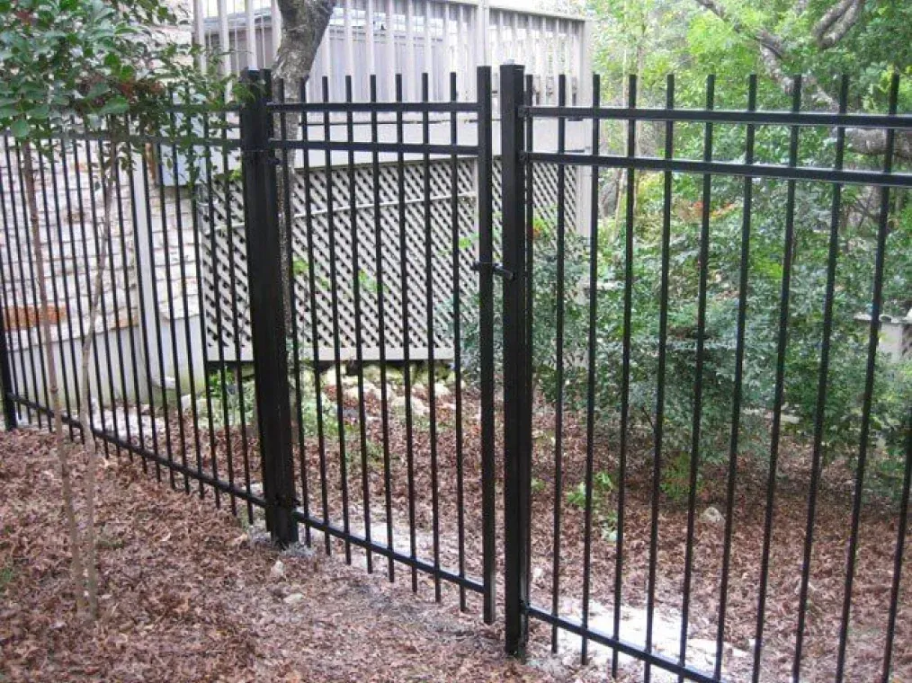 A black metal fence with a gate in the middle of it