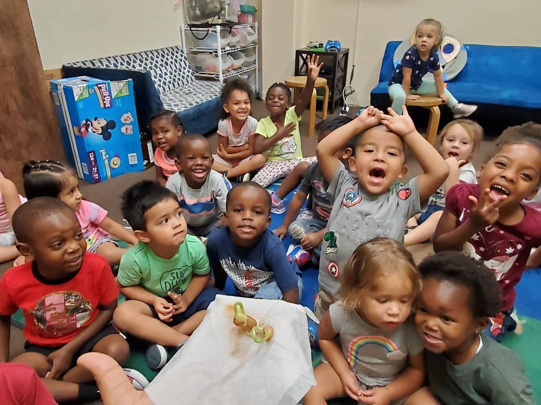 A group of children are sitting on the floor having fun.
