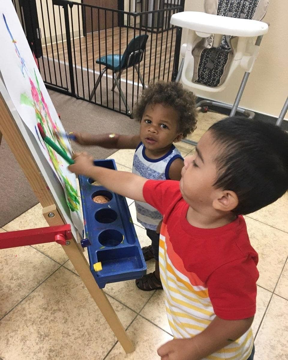 Two young boys are painting.