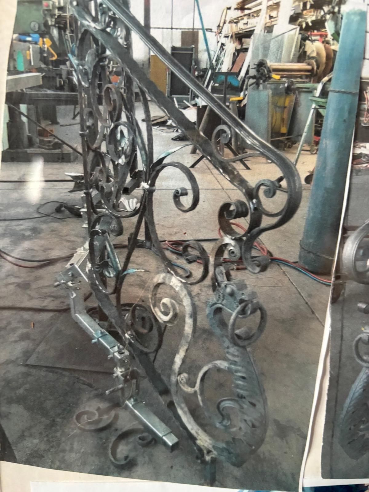 Una stanza non rifinita con un montante metallico della scala su un pavimento piastrellato, che mostra una stretta fessura tra le pareti bianche.