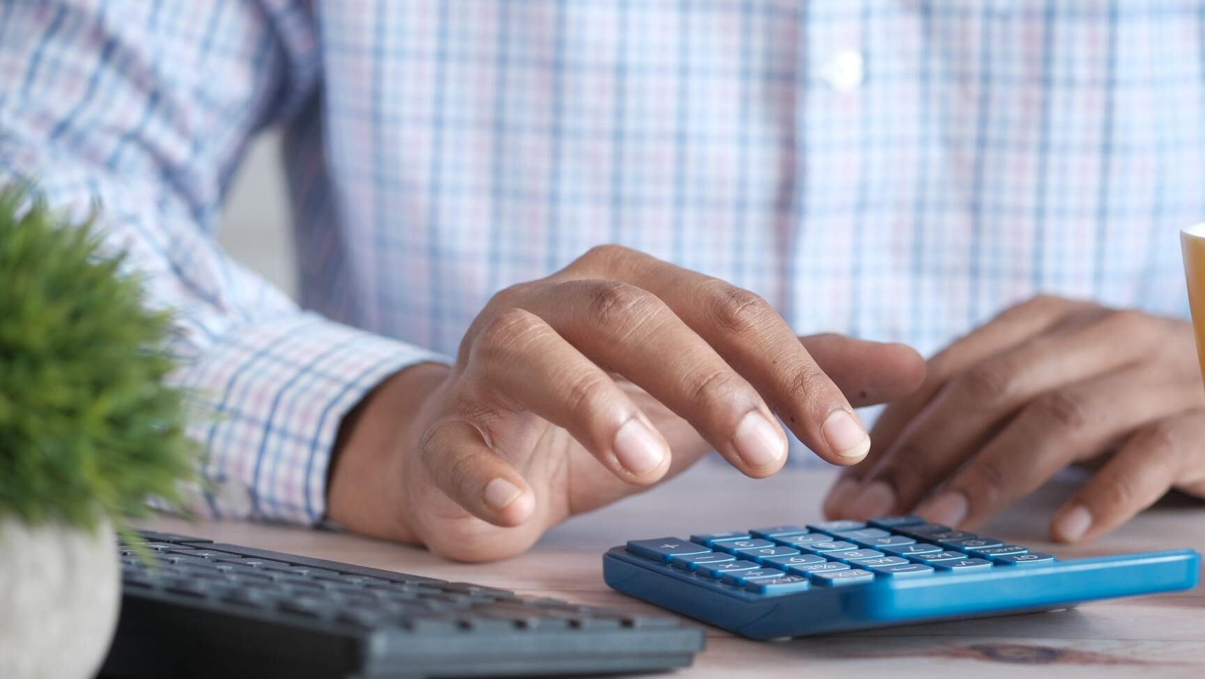 man on computer keyboard taxes in spanish