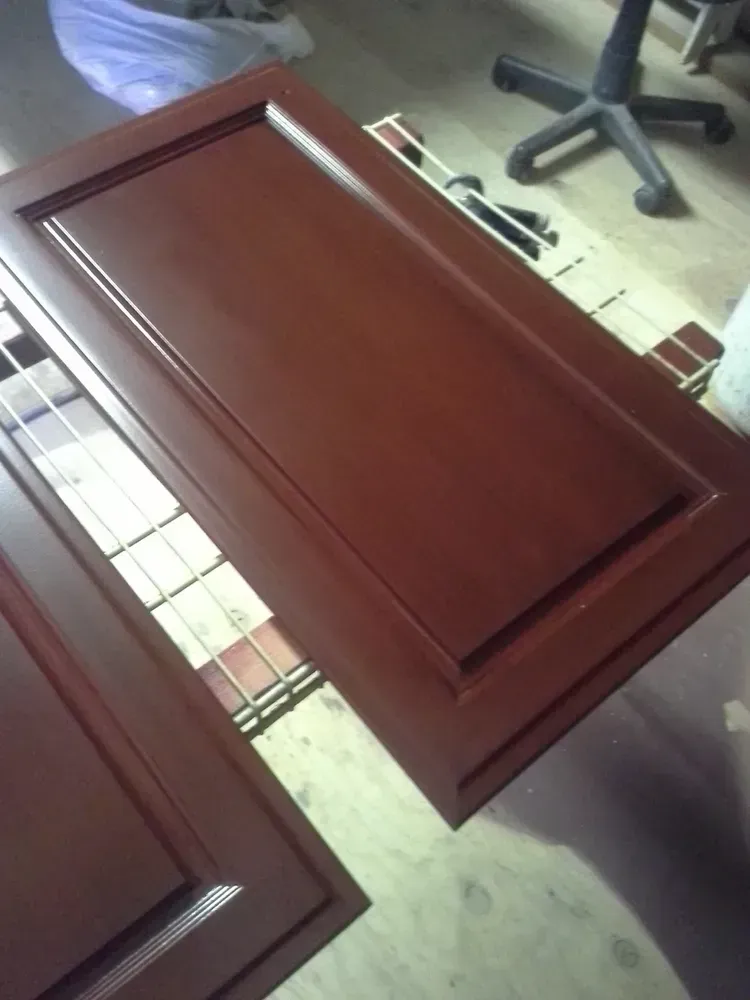 A wooden door is laying on the floor next to a chair