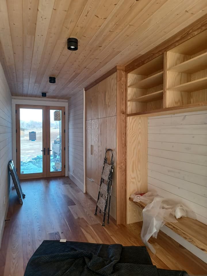 A hallway with wooden shelves and a ladder on the floor