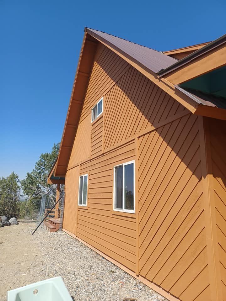 A large brown house with a roof and stairs