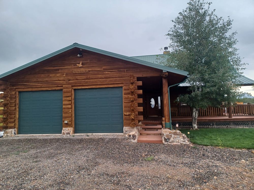 A log cabin with two garage doors and a porch