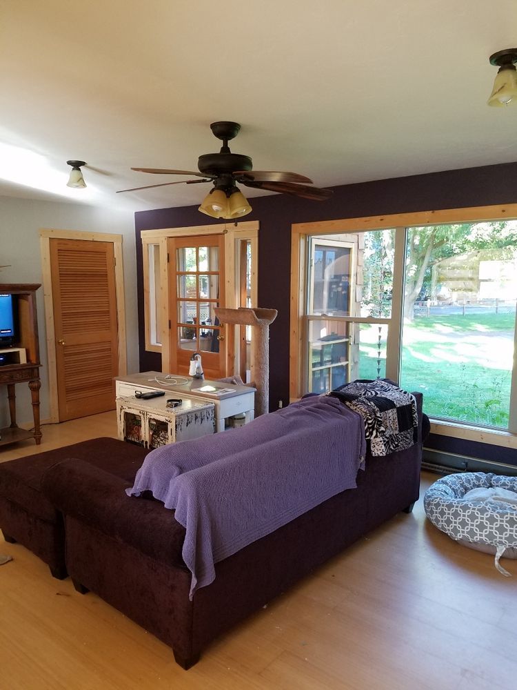 A living room with a purple couch and a ceiling fan