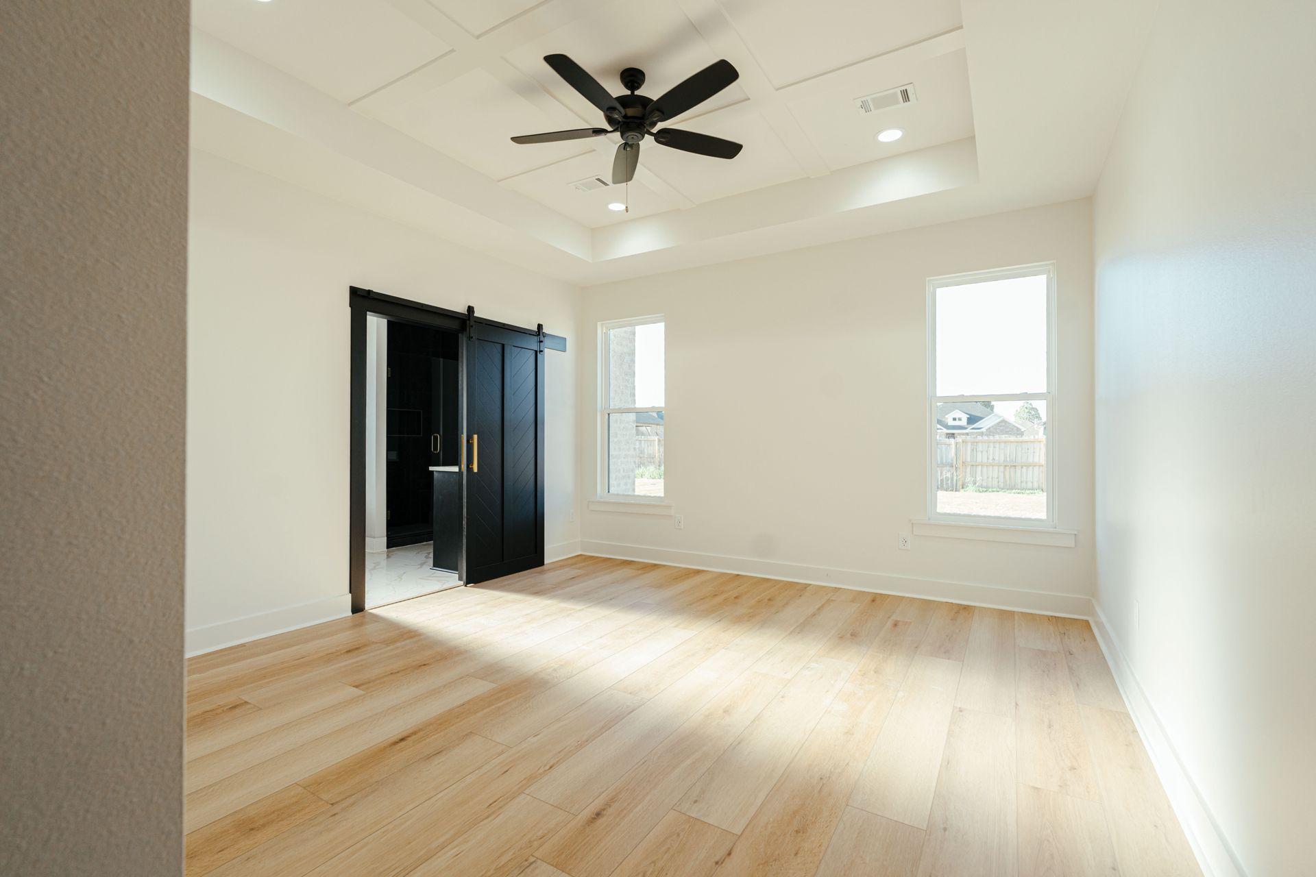 Bright bedroom with natural light and a ceiling fan.