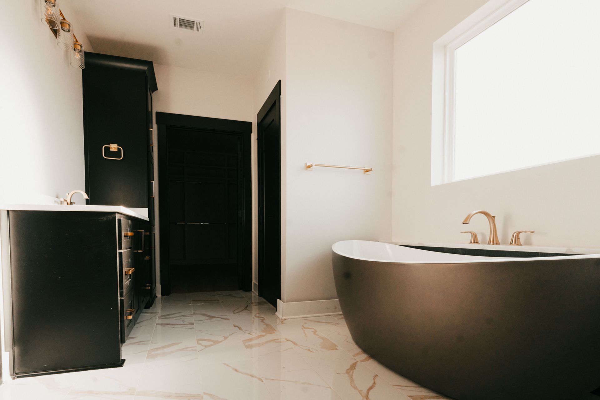 Elegant bathroom with a black freestanding bathtub and luxurious finishes.