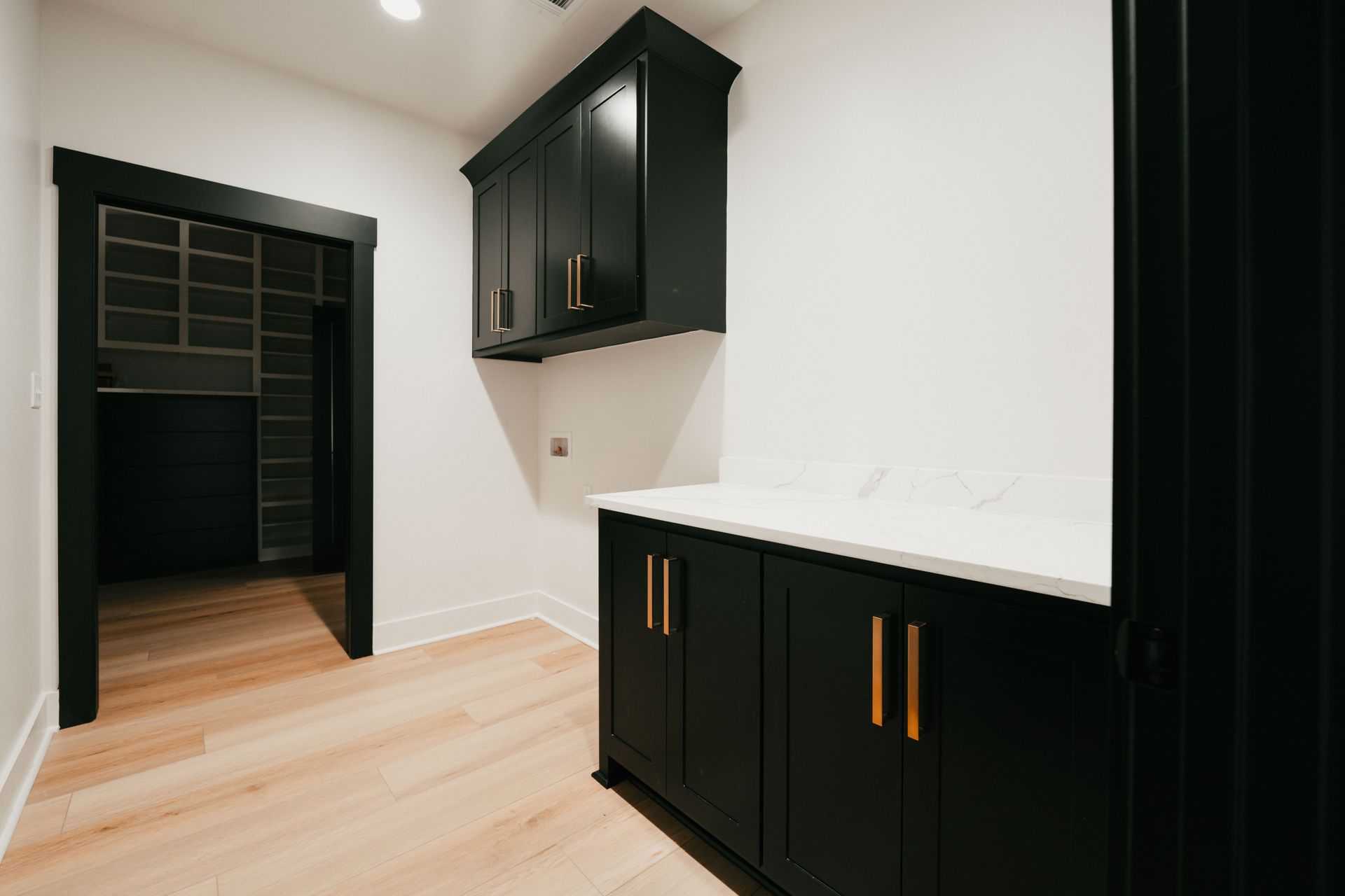 Laundry room with black cabinetry and ample counter space.