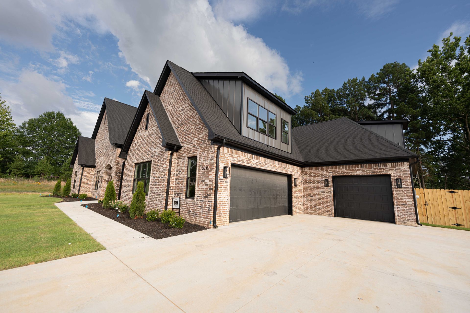 Elegant brick home with a large garage and spacious driveway.