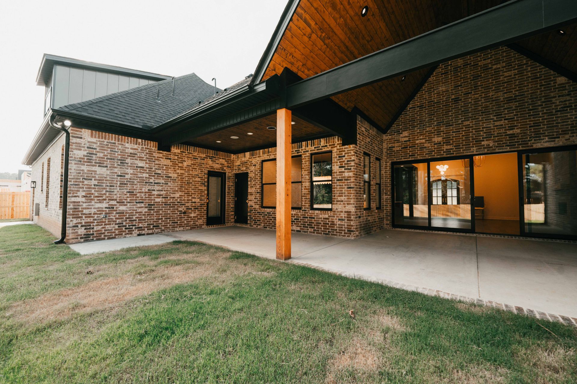 A back patio area featuring a brick exterior and covered outdoor living space.