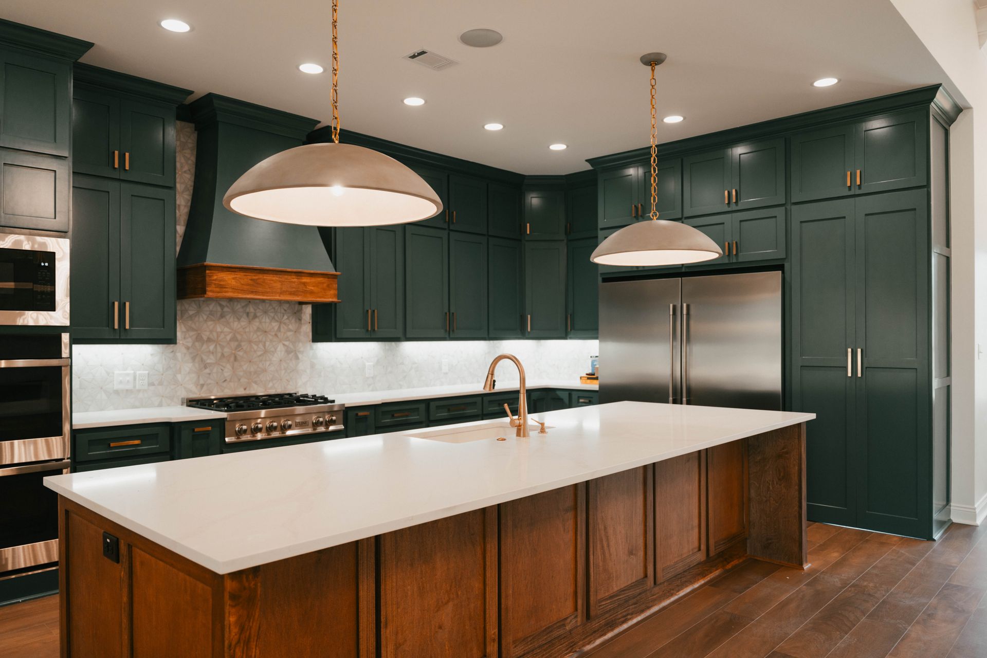 Open kitchen with green cabinets, white countertops, and a large island for entertaining.