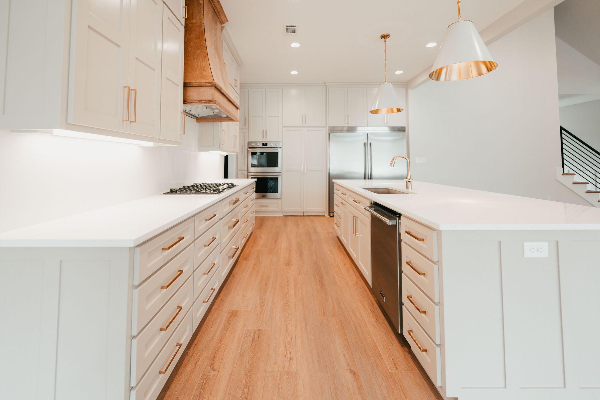 Sleek kitchen with wooden accents, white cabinetry, and stainless steel appliances.