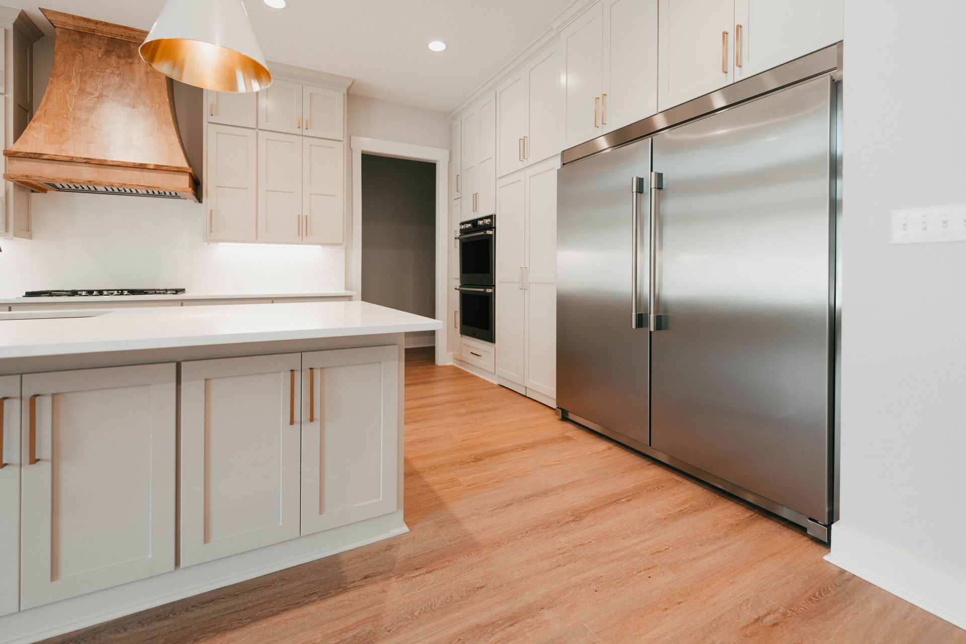 A modern kitchen featuring a large double-door stainless steel refrigerator and wood accents.
