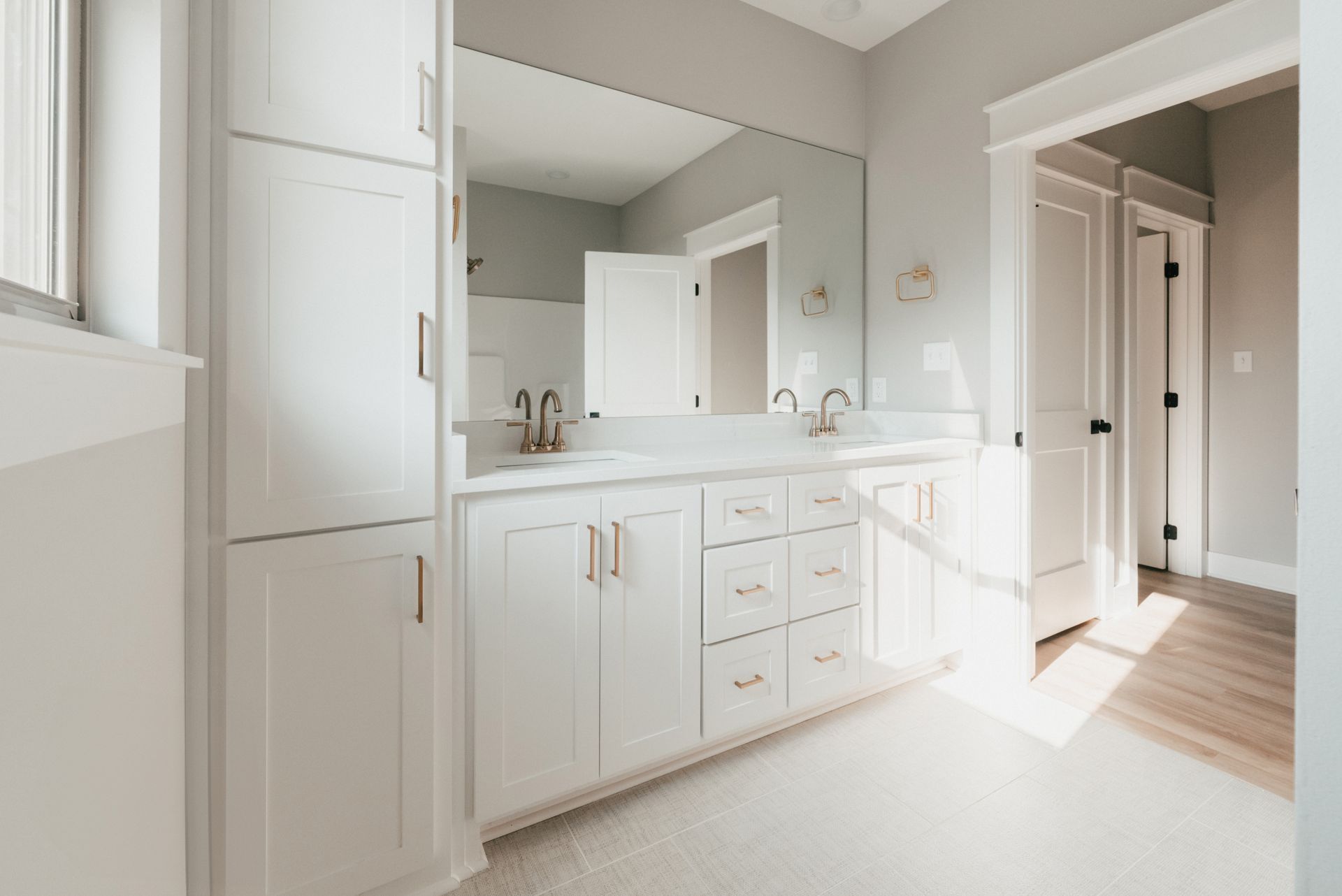 Spacious bathroom with double vanity, white cabinets, and a walk-in shower.