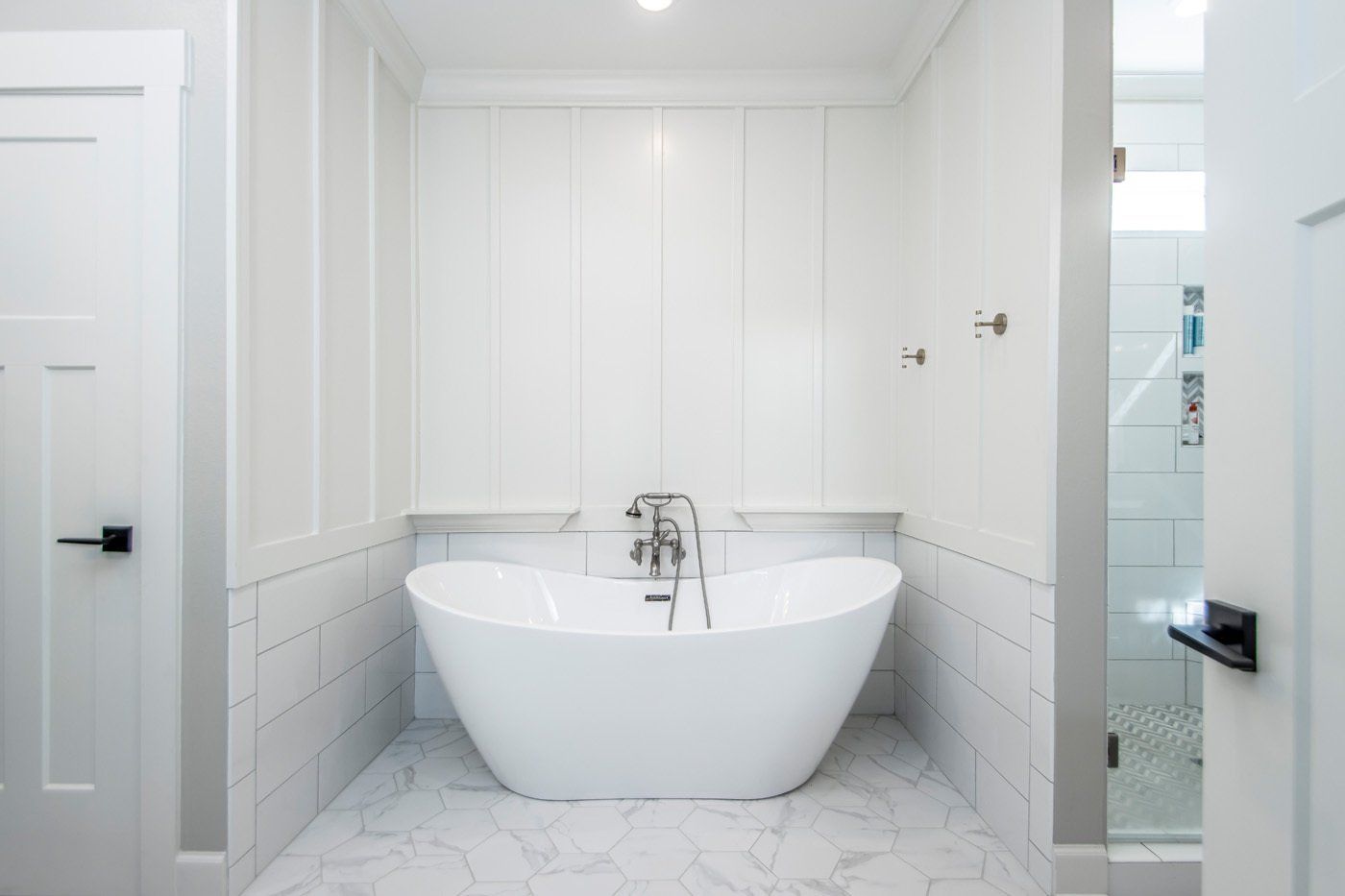 Luxurious bathroom featuring a standalone soaking tub and marble tile flooring.