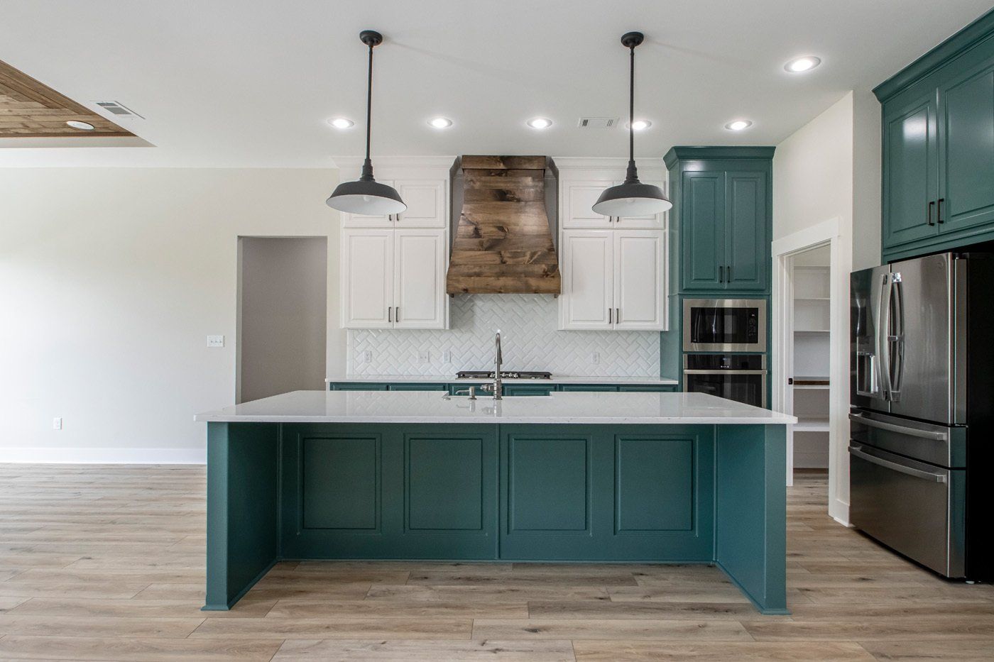 Bright kitchen with green cabinetry and island, perfect for entertaining.