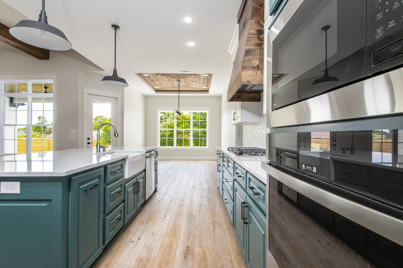 Spacious kitchen with green cabinetry, modern appliances, and a large island.
