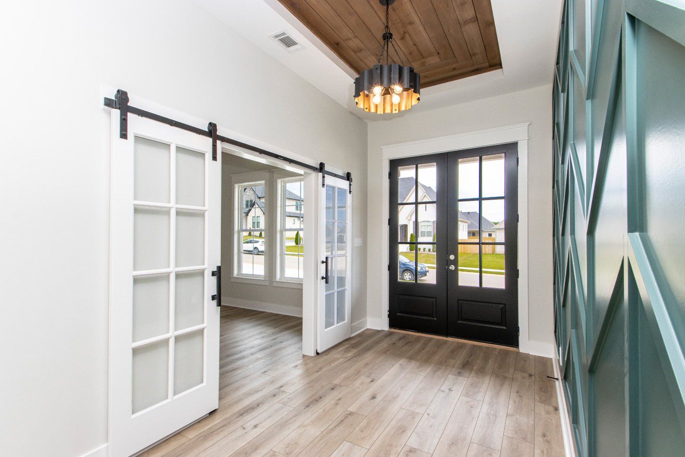 Entryway with barn doors and wood ceiling details, leading into the living space.