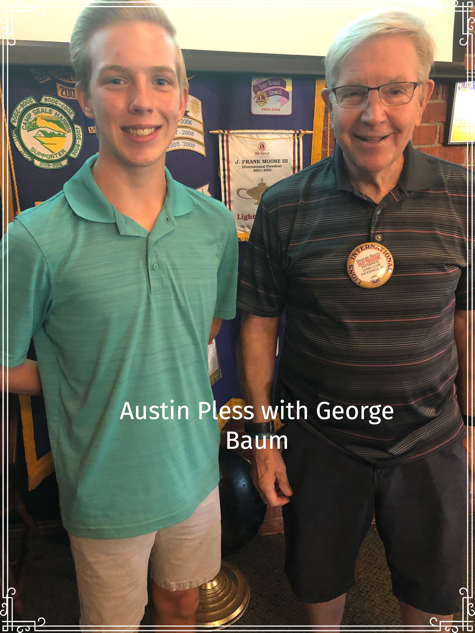 Austin Pless and George Baum pose together indoors. Austin wears a green polo shirt and khaki shorts. George wears a patterned shirt and dark shorts.