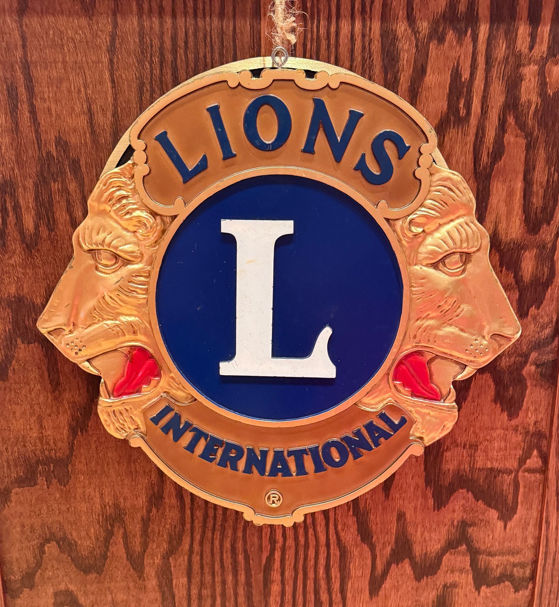 Lions Club emblem with gold lions, blue circle with white