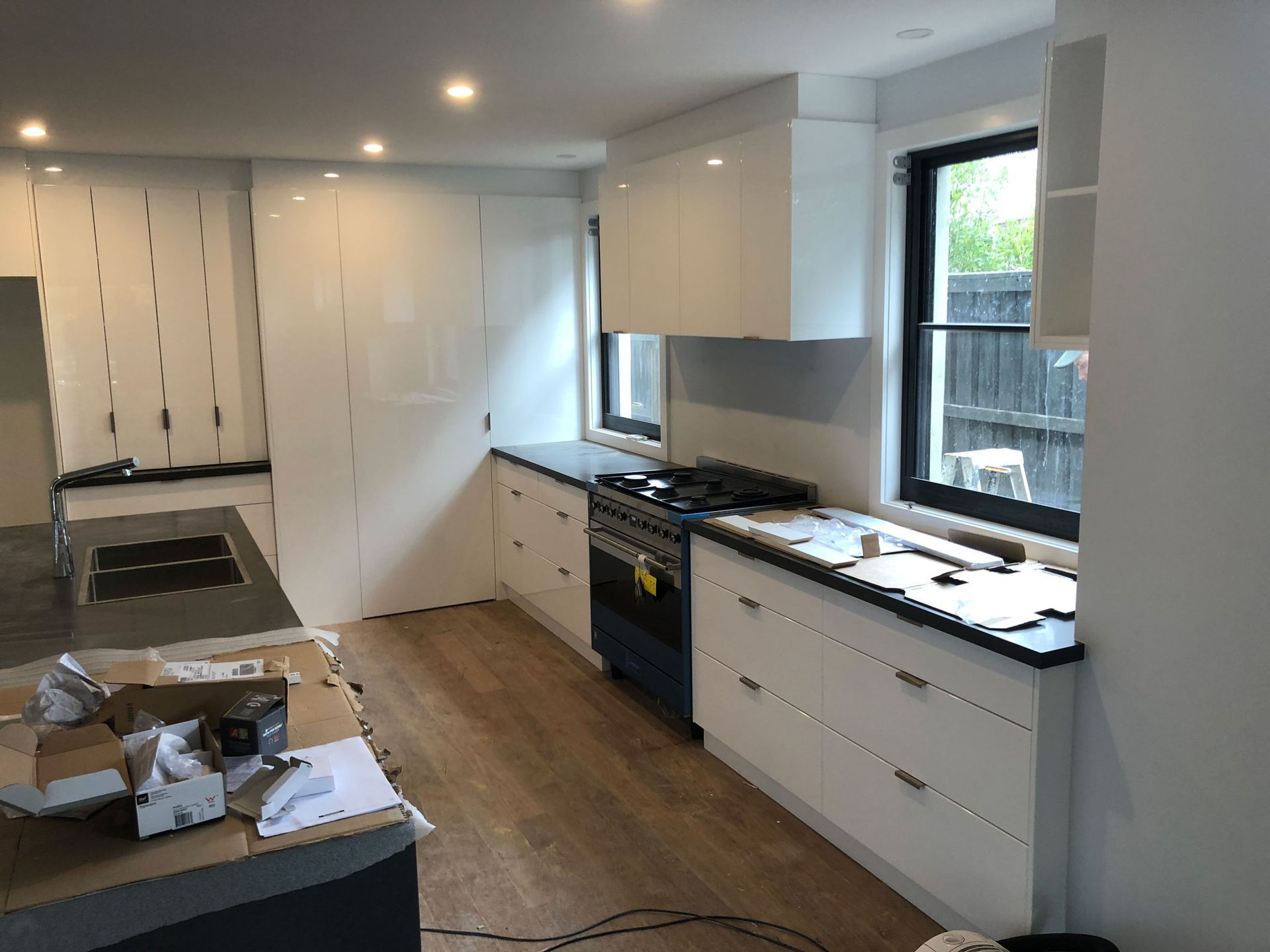 Newly renovated kitchen with white cabinets, dark countertops, and stainless steel appliances.