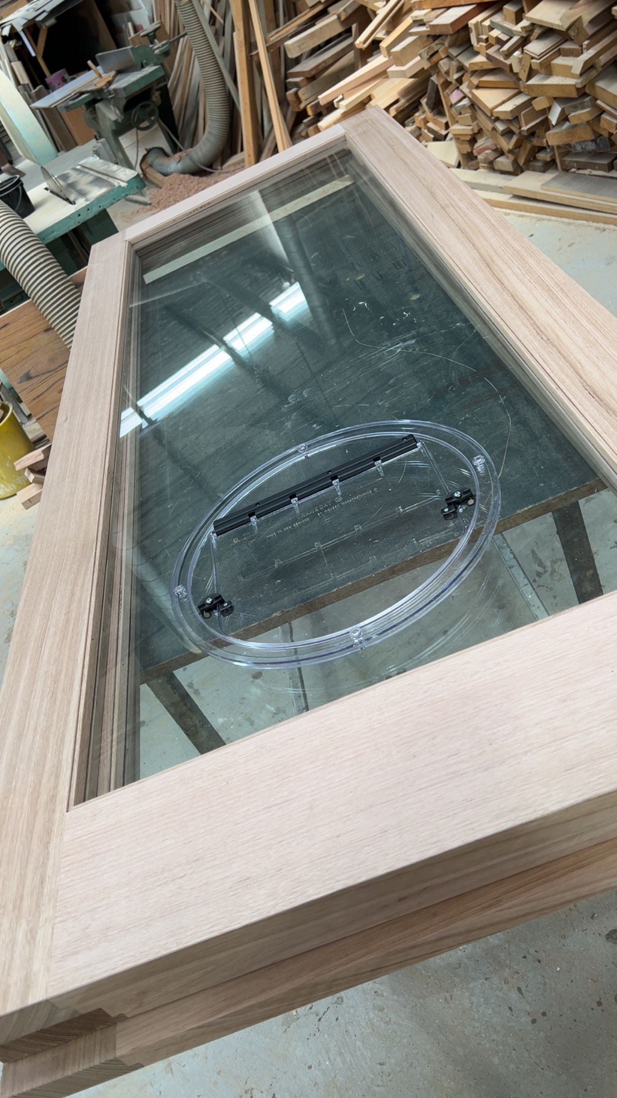 Wooden framed door with a large glass panel. Circular air vent in the center.