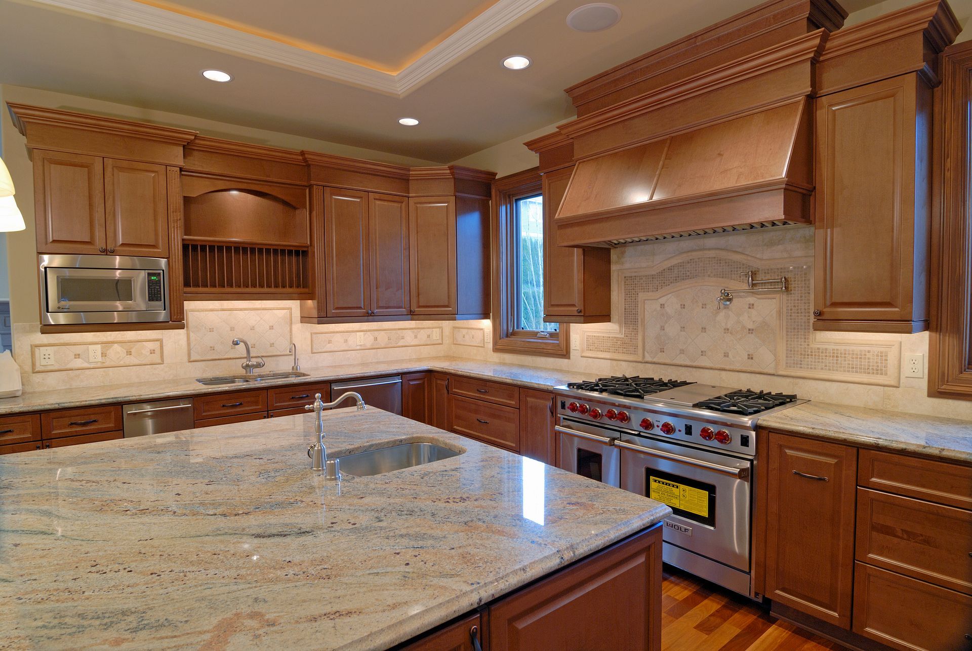 Luxury kitchen with wood cabinets, granite countertops, and stainless steel appliances.
