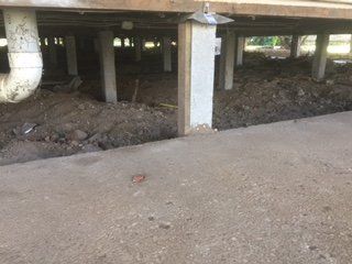 The foundation of a house is being built underneath it.