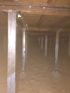 A dark basement with a lot of wooden beams and pillars.