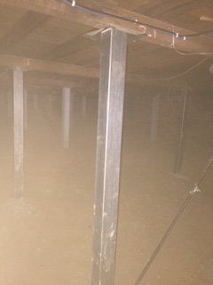 A very dark room with a metal pole in the middle of it.