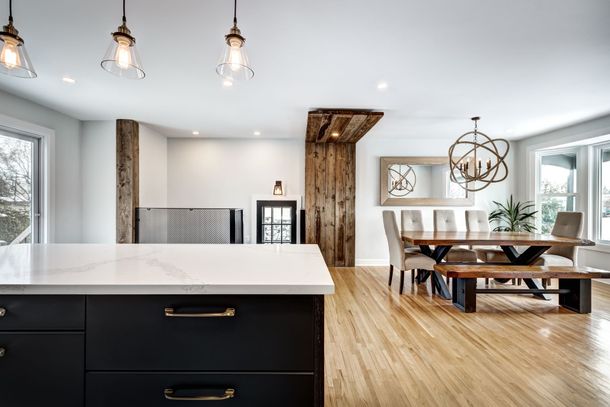 A kitchen with a large island and a dining room with a table and chairs.