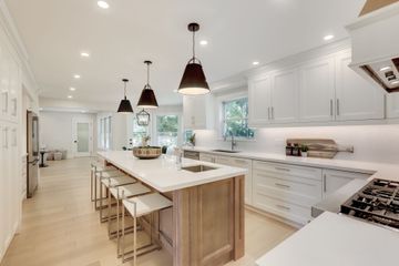 A kitchen with white cabinets and a large island.