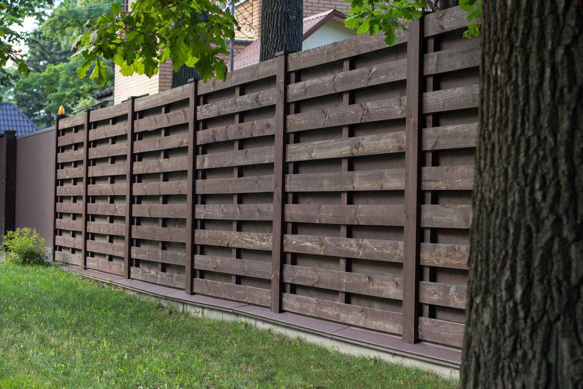 Scandinavian-style wooden fence surrounding a lush green lawn.