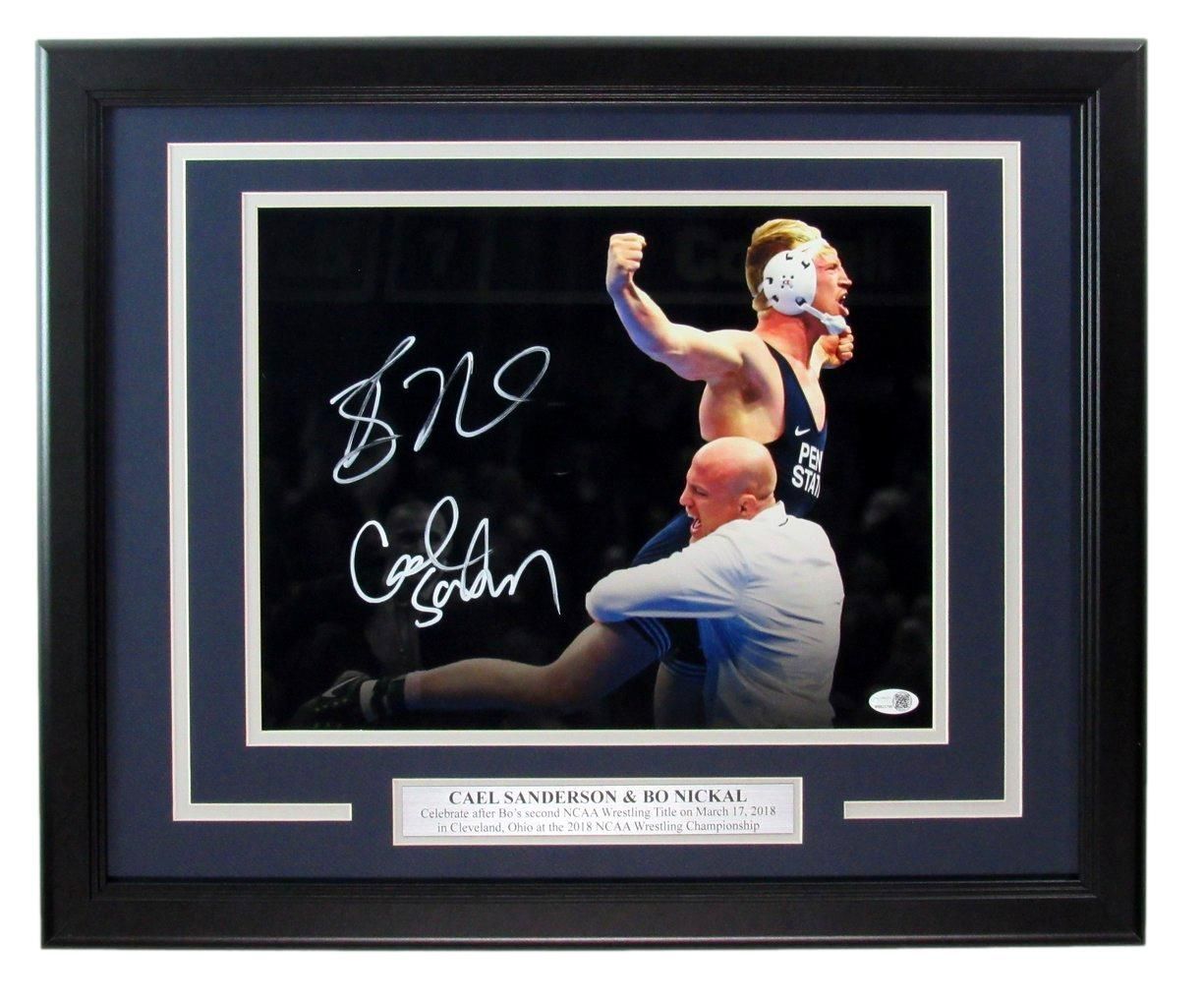 Framed photo: Wrestler celebrating victory, signed by him and his coach. Dark blue matting, black frame.