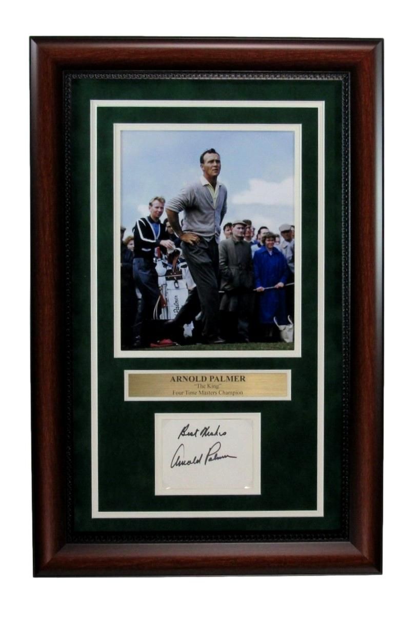 Framed photo of golfer Arnold Palmer in action, signed autograph. Green and brown frame, gold name plate.