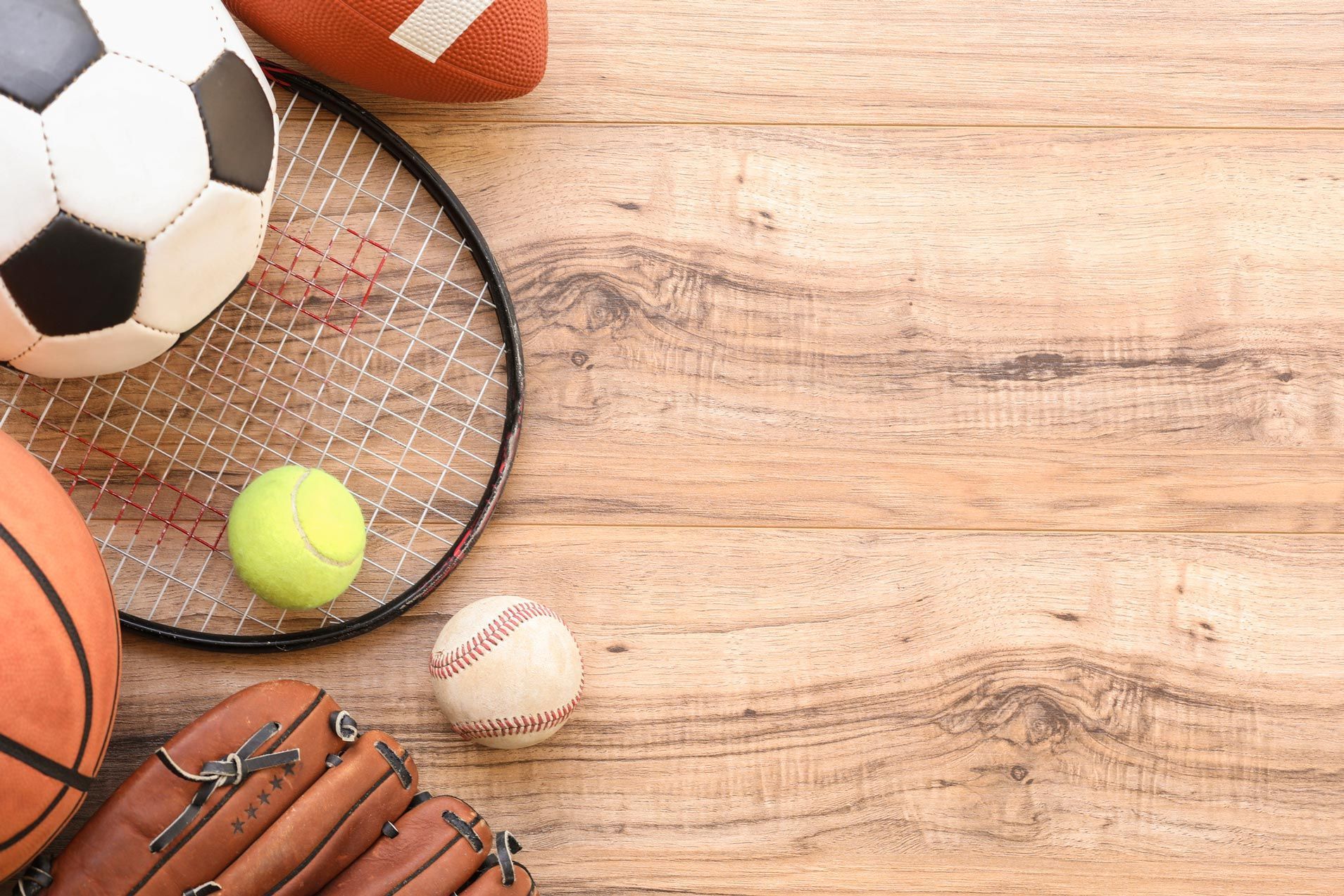 Balls and sports gear highlighting sport memorabilia on a natural wooden surface.