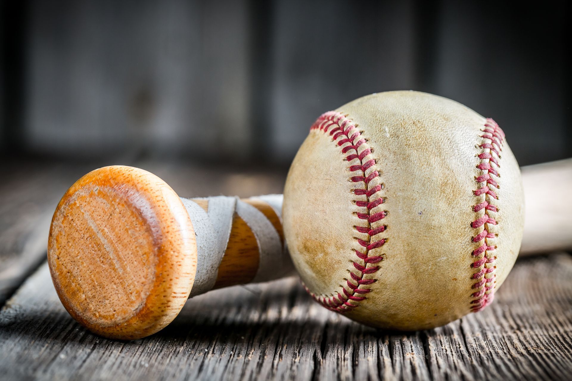 Close-up of a baseball bat and ball on wood, showcasing silent auction sports memorabilia.