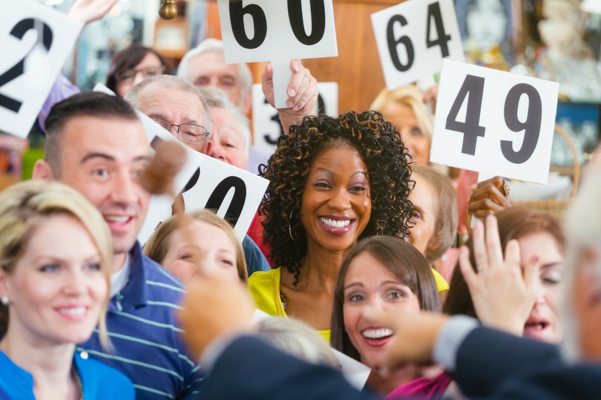 A crowd of bidders at a live auction in an antique store.