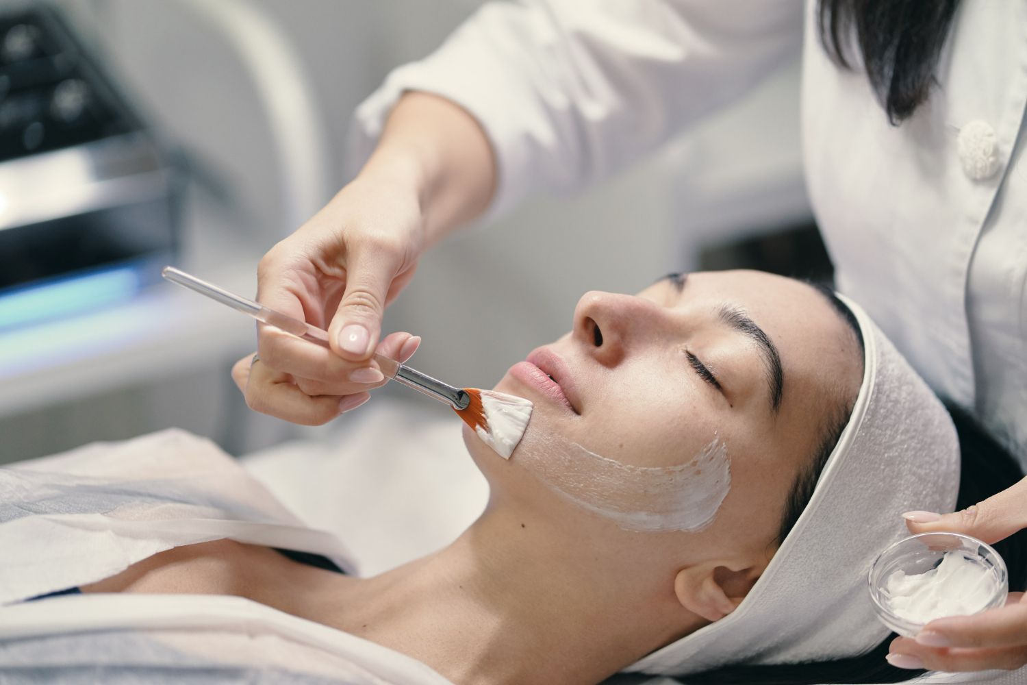 A woman is getting a facial treatment at a beauty salon.