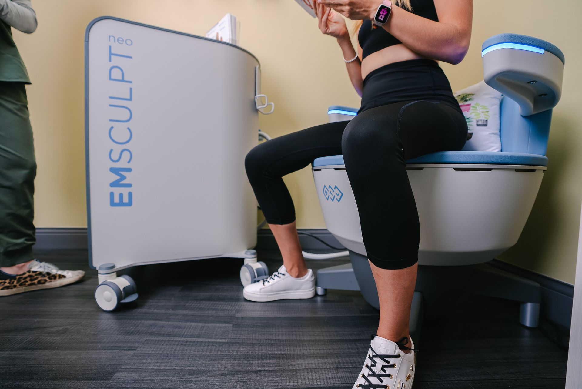 A woman is sitting on a toilet reading a book.
