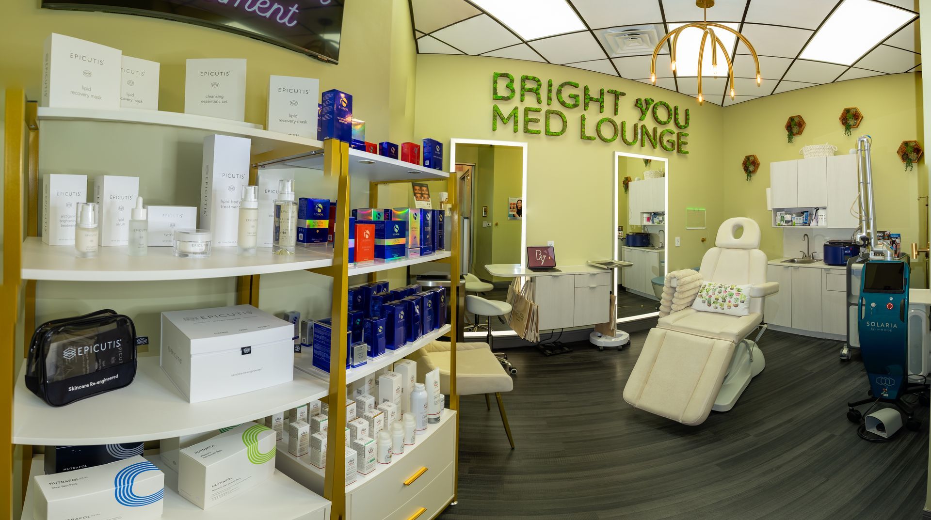 Bright You Med Lounge interior with product shelves, treatment chair, and medical equipment. Green and gold accents.