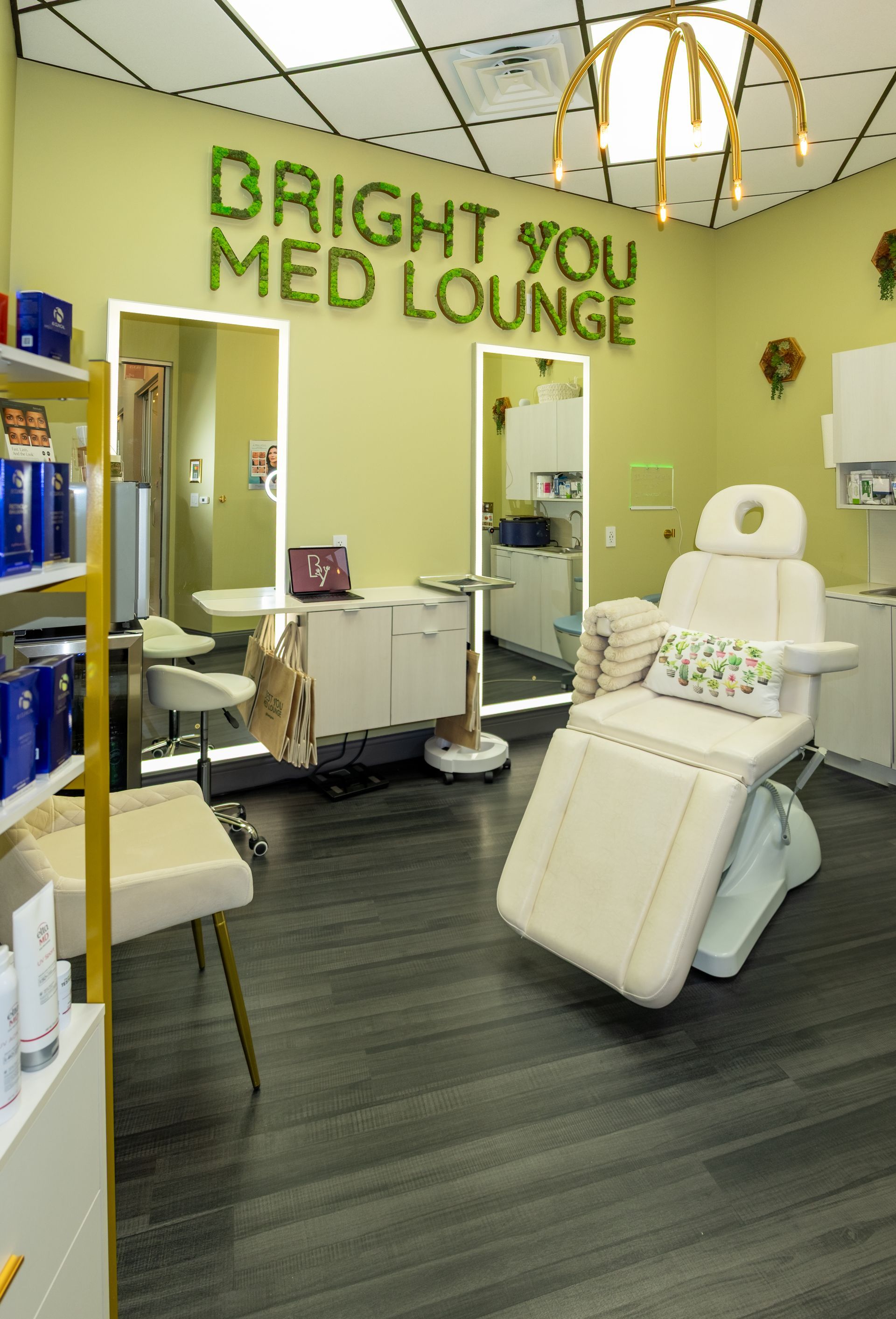 Interior of Bright You Med Lounge, with medical chair, mirrors, products, and logo sign.
