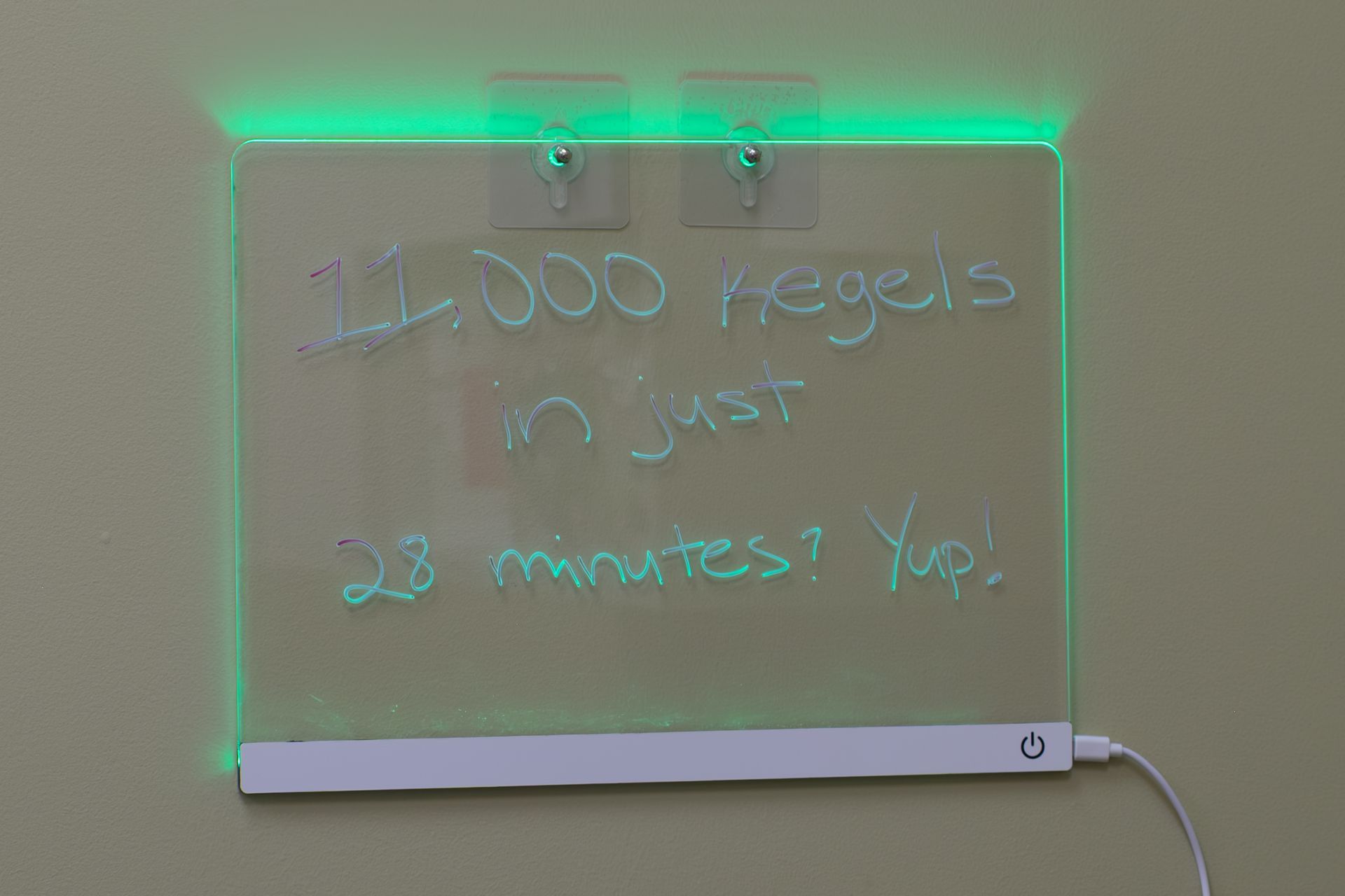 A glow in the dark chalkboard is hanging on a wall.