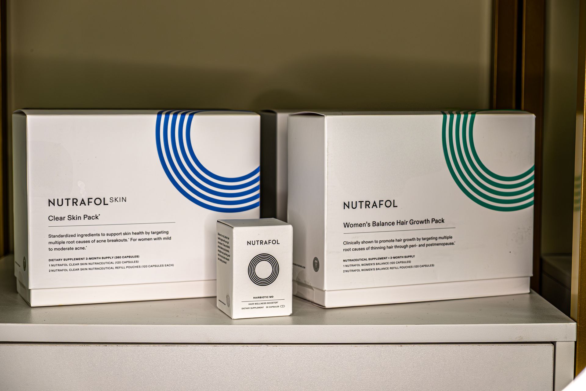 Three white boxes with blue and green circles on them are sitting on a table.