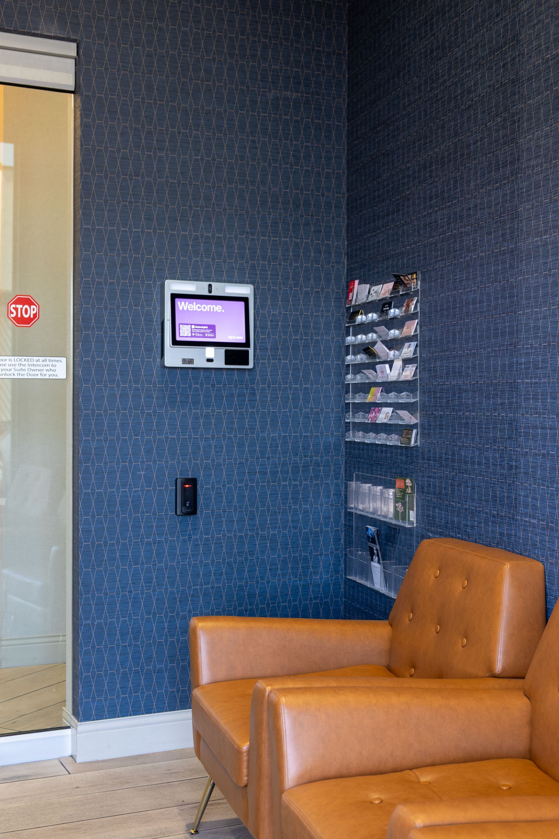 A waiting room with two chairs and a television on the wall.
