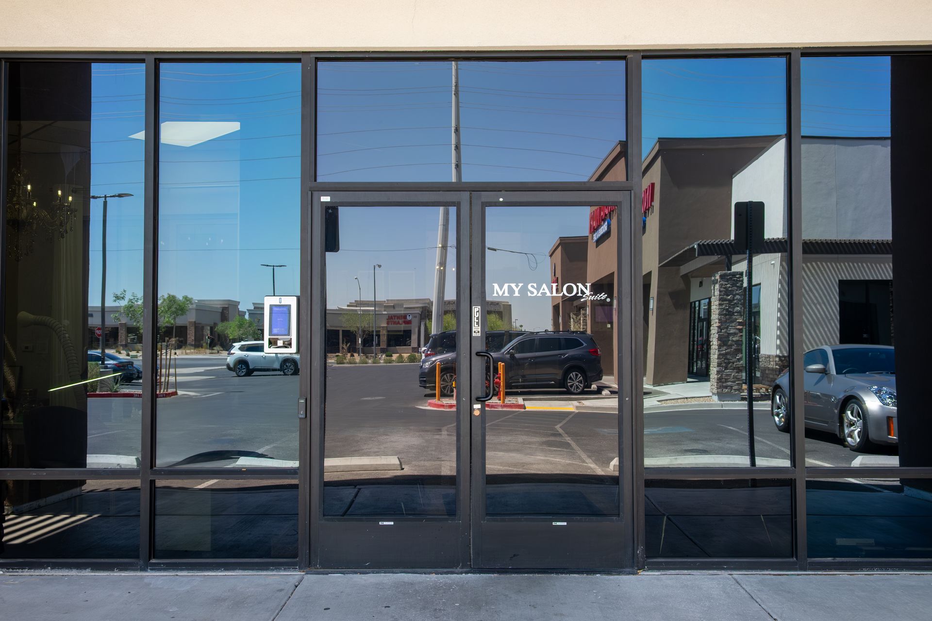 A store front with a lot of windows and a car parked in front of it.