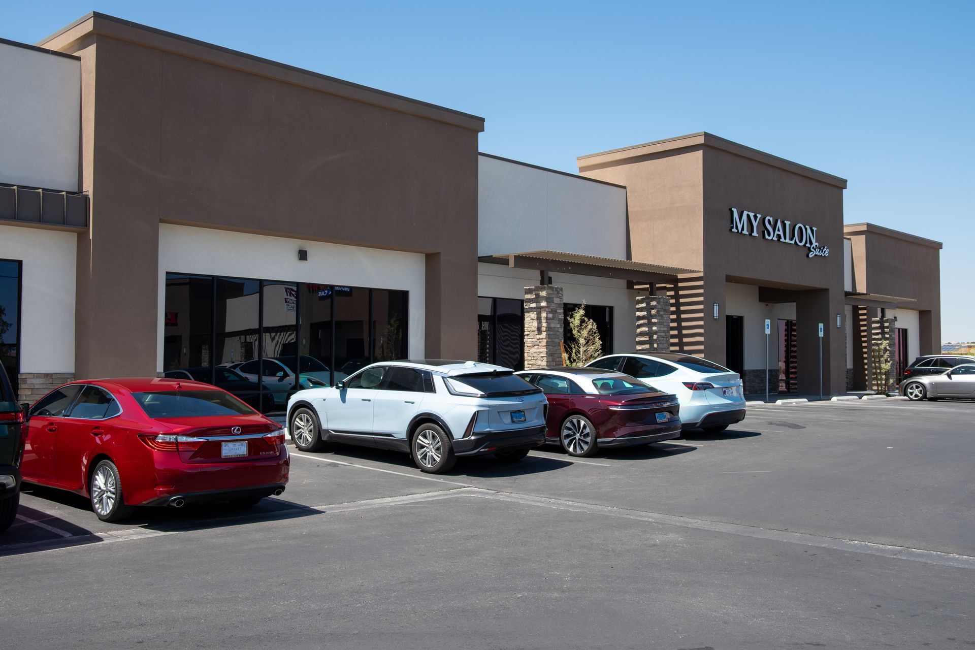 A row of cars are parked in front of a building