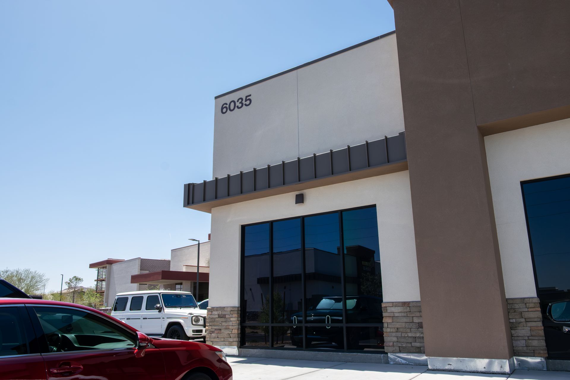 A red car is parked in front of a building with the number 80315 on it